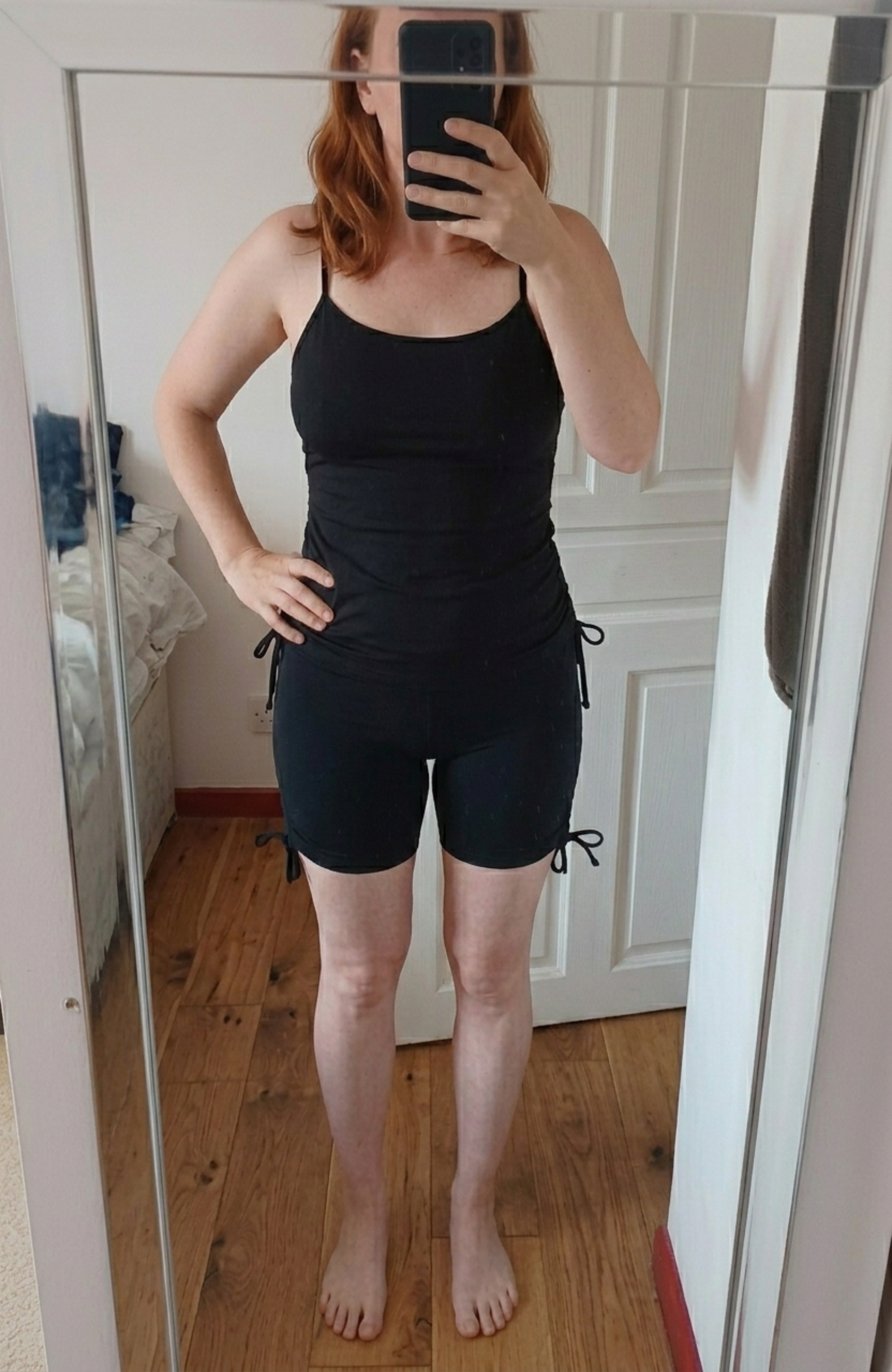 Photo cliente d'Eclypse se prenant en selfie devant son miroir. Elle porte l'ensemble de bain semi-couvrant composé du short et du top noir, montrant la coupe et le tombé du maillot. Image